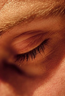 A close-up of a person with their eyes closed